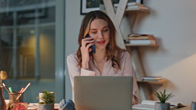 Professional communicating mobile phone consulting in evening office closeup.
