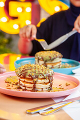 Girl friends eating dubai chocolate kunafa pancakes served at a fancy restaurant cafe.