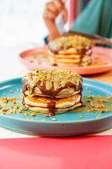 Girl friends eating dubai chocolate kunafa pancakes served at a fancy restaurant cafe.