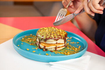 Girl friends eating dubai chocolate kunafa pancakes served at a fancy restaurant cafe.