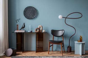 Sophisticated interior with a deep blue accent wall, smoked glass console, and sculptural decor...