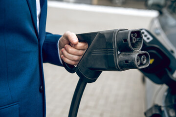 Male refilling car with fuel at gas station