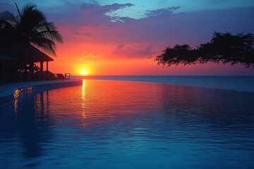Beautiful sunset over the pool at a luxury Zanzibar hotel, with views of the Indian Ocean and palm trees.