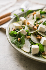 Salad with arugula, pear, feta cheese and walnuts