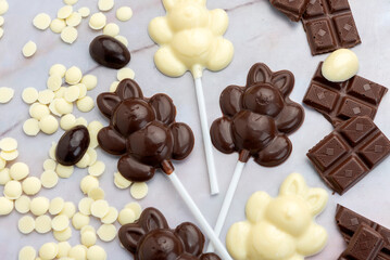 Dark and white chocolate Easter eggs and bunnies with fruit-colored candies and chocolate bars on a counter