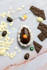 Dark and white chocolate Easter eggs and bunnies with fruit-colored candies and chocolate bars on a counter