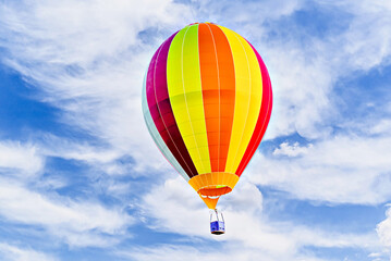 Fototapeta premium Colorful hot air balloon flying over blue sky with white clouds