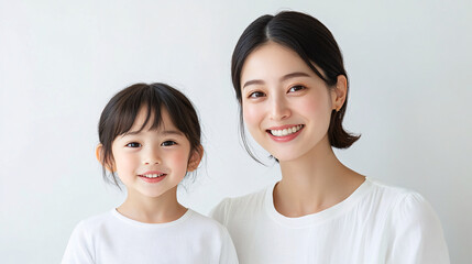 Studio Portrait of a Happy Asian Mother and Daughter Hugging: A Family Concept Featuring a Japanese Young Mother and Her Cute daughter Interacting and Smiling in Front of a Plain White Background,