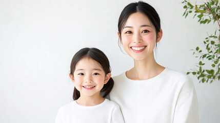 Studio Portrait of a Happy Asian Mother and Daughter Hugging: A Family Concept Featuring a Japanese Young Mother and Her Cute daughter Interacting and Smiling in Front of a Plain White Background,