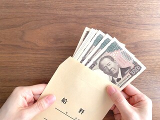 給料袋に入ったお金を持つ手元