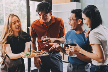 Asian office colleagues and friends enjoy a daytime BBQ with pizza and beer, celebrating Halloween and cheering for their favorite soccer team, creating a lively atmosphere filled with joy.
