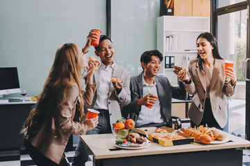 Asian office colleagues and friends enjoy a daytime BBQ with pizza and beer, celebrating Halloween and cheering for their favorite soccer team, creating a lively atmosphere filled with joy.