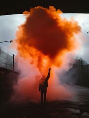 Obraz premium Person with Orange Smoke Bomb Raising Hand in Urban Setting