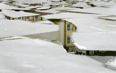 Thin ice over a river, with large shards of ice separated by gaps of ice-free water