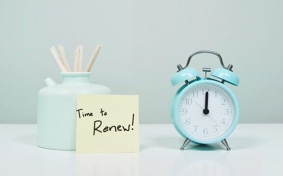 "Time to Renew" Sticky Note on Blue Alarm Clock – Minimalist Concept for Insurance Renewal and Timely Reminders  