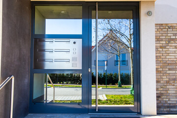 Anthrazitfarbene Haustür mit Glas und Gegensprechanlage an einem Mehrfamilienhaus