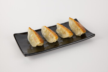 Japanese Gyoza Dumplings on Black Plate with Golden Crispy Edges