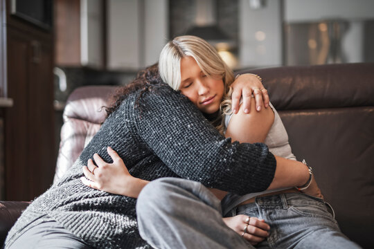 Compassionate mother comforting depressed sad teen girl, hugging daughter with love