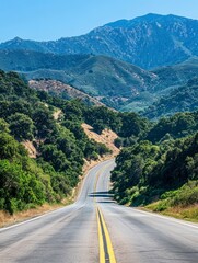 Fototapeta premium Driving on Scenic Mountain Road Through Green Forest Under Clear Blue Sky