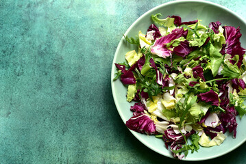 Mix of fresh salad leaves on a plate. Top view with copy space.