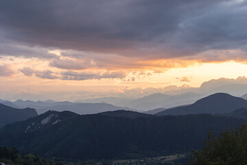 Fototapeta premium Layered mountains with cloudy sky at sunset. Landscape of the mountains