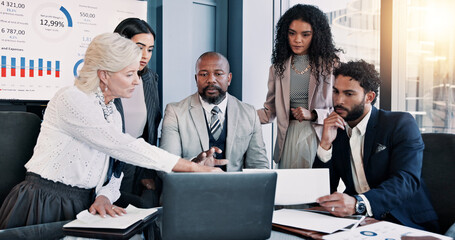 Business people, laptop and meeting with group for company performance, report or review at office. Data, paperwork or analytics with graph, chart or project statistics for finance at workplace