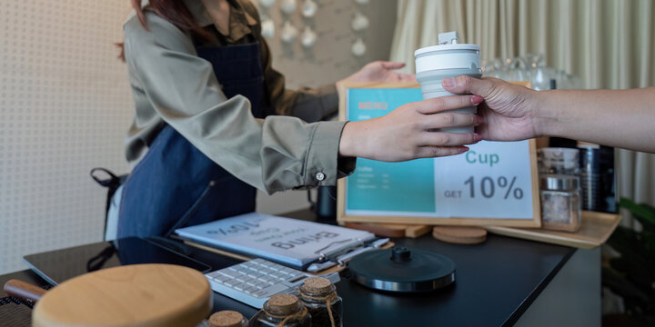 Sustainable Consumer Choices and Rewards. A customer receiving a discount for using their own cup at a cafe.