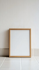 Empty wooden frame leaning against a neutral wall with tiled floor, ideal for mockup use