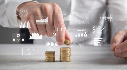 Stack of coins with a financial growth graphs.
