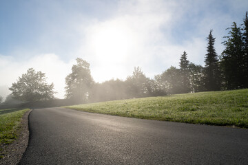 Road in the mountains  on a sunny and foggy morning