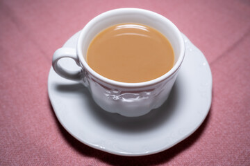 Coffee with milk on a pink table