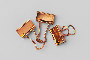 Copper binder clip on grey background