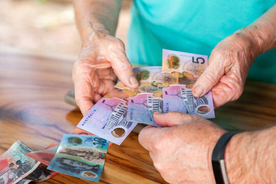 Hands of old person handing over money to a middle aged man
