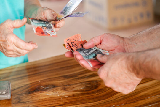 Elderly hands paying bill in cash