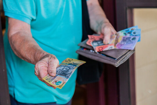 Senior citizen handing over cash at home front door