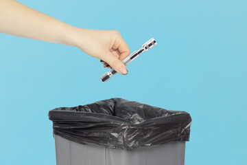 throw screwdriver bit with replaceable head into trash can, screwdriver bit in hand in front of...