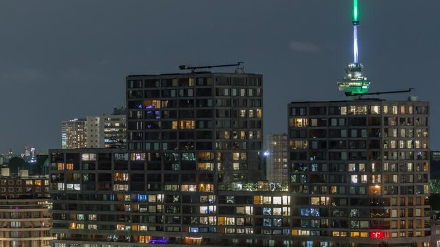 Panoramic aerial timelapse of Katendrecht peninsula at night and Maashaven harbour in Rotterdam, The Netherlands. Illuminated city skyline, modern skyscrapers and Euromast, houses on a waterfront