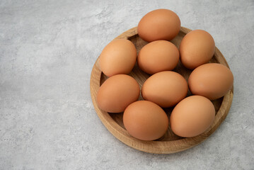 Chicken eggs lie on a wooden plate. Fresh egg for morning breakfast. Concept of agricultural products and natural food