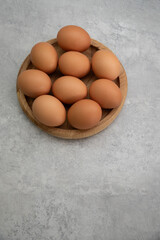 Chicken eggs lie on a wooden plate. Fresh egg for morning breakfast. Concept of agricultural products and natural food