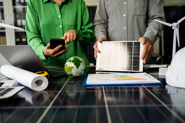 Two colleagues discussing data working and tablet, laptop with on Construction Site project, green energy and solar panel concept.
