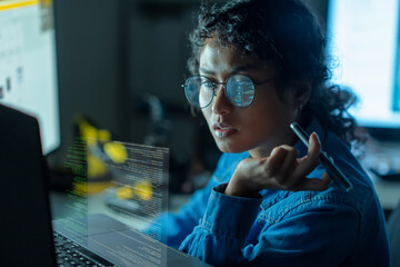 An Asian woman collaborates on a SaaS platform, writing code on multiple screens in a vibrant...