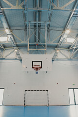 Basketball hoop hanging in modern empty gym with epoxy floor © Doralin