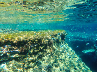 Ocean blue underwater with sunrays, Underwater Sea Deep Water Abstract Sunshine, sea wave, clean waters in summer time, Natural underwater seascape, sand on ocean floor and water surface with sunlight