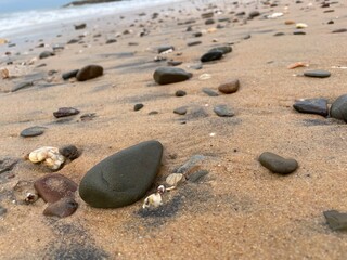 footprints on the beach, stones on sand, ocean