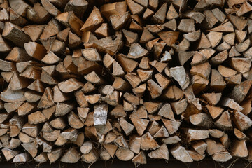 Stacked firewood creating intricate pattern of wooden logs