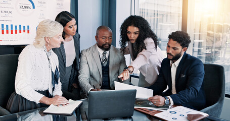 Business people, laptop and meeting with graphs for company performance, report or review at office. Group, paperwork or analytics with discussion, chart or project statistics for finance workplace