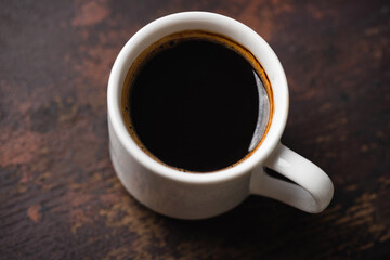 Cup of black coffee espresso on a rustic wooden table background. Caffeine fix