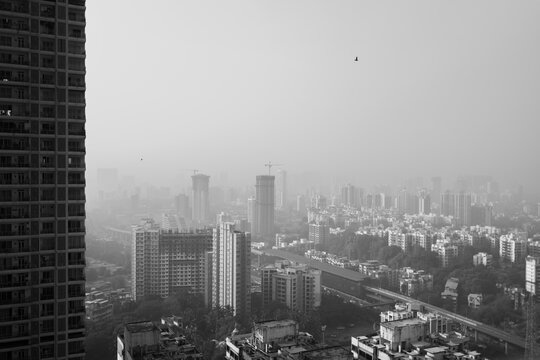 black and white misty cityscape with tall buildings 