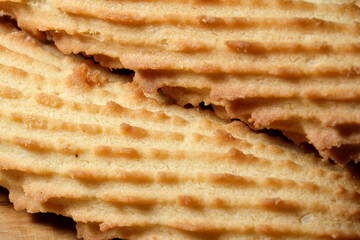 Delicate crispy wafers resting on a wooden board under warm light