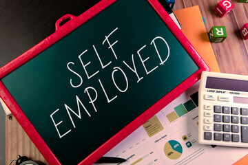Self employed message on a chalkboard with office tools